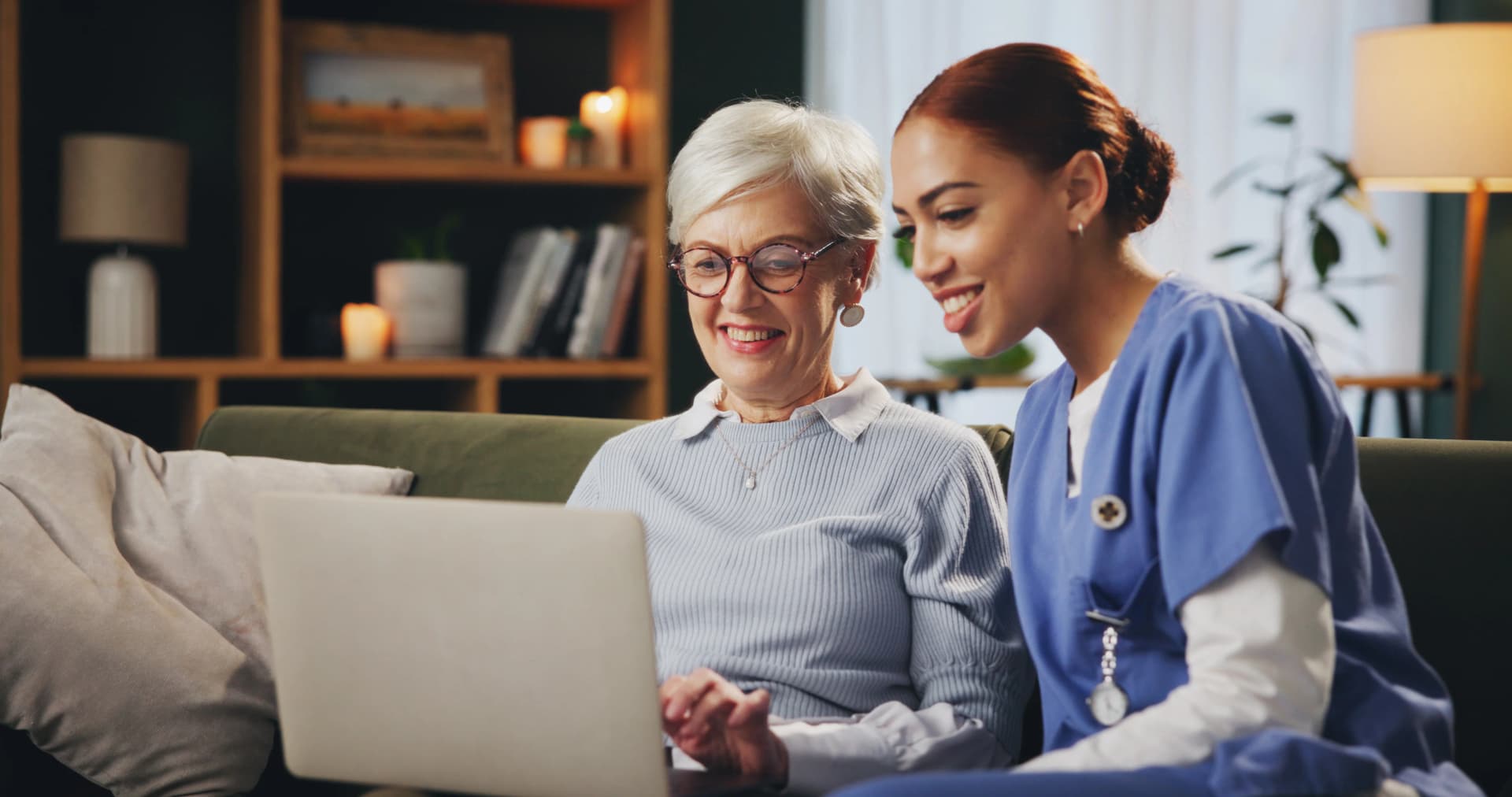 Senior and caregiver using laptop together