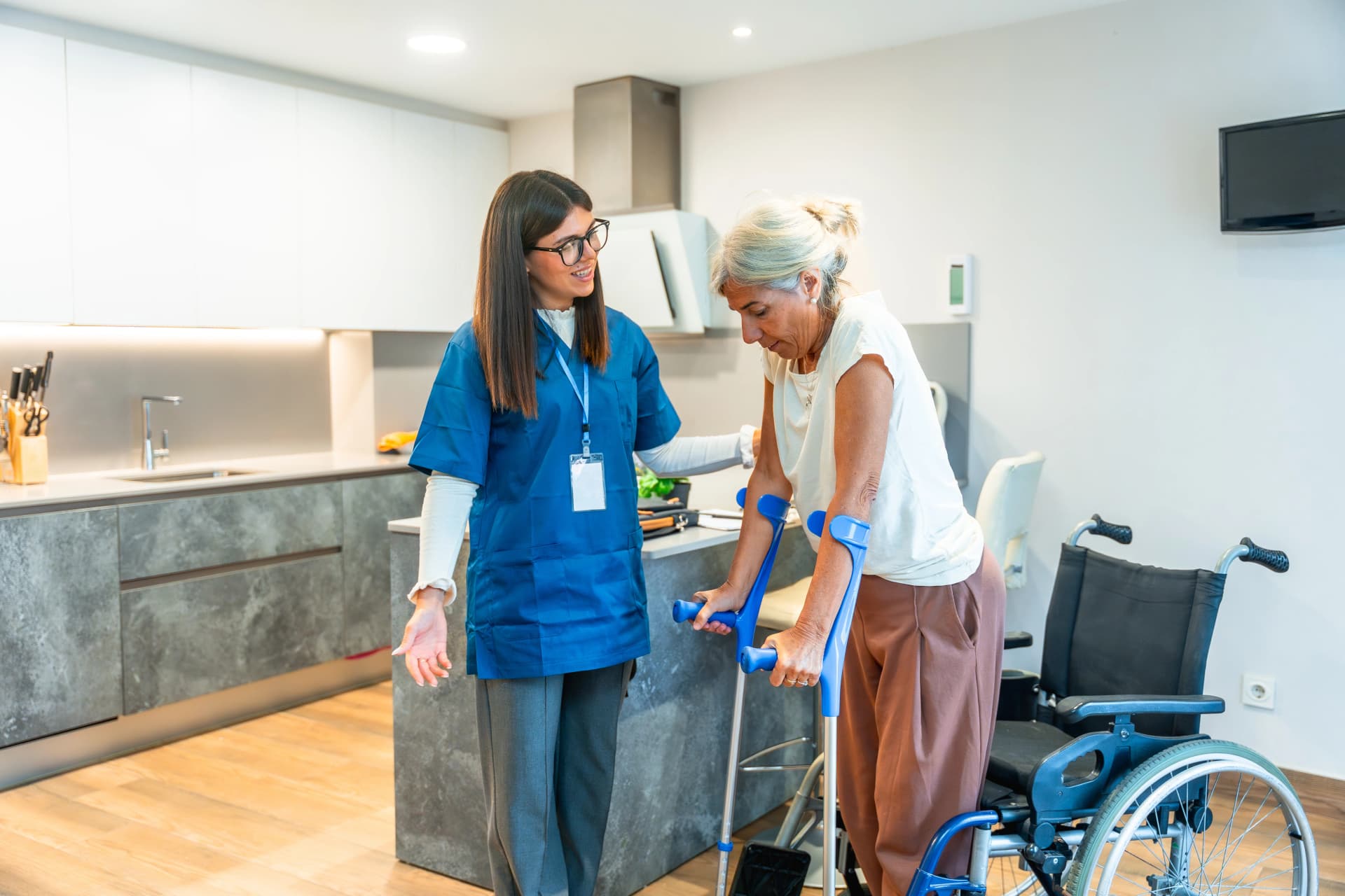 Physical therapist assists senior woman with crutches